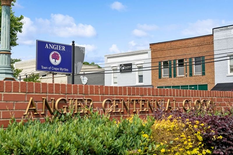 Angier Centennial Clock sign and downtown storefronts in Angier, North Carolina.