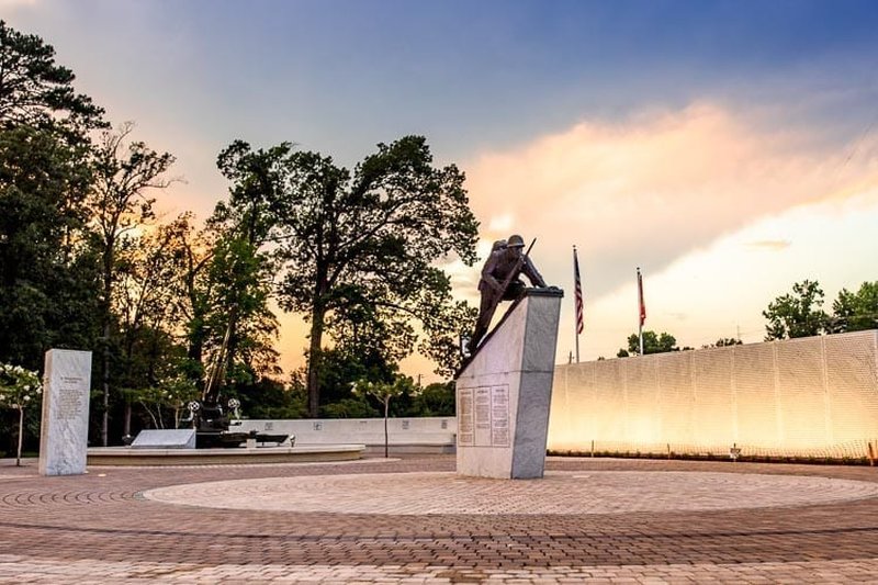 A Marine memorial statue and engraved wall at sunset in Jacksonville, NC.
