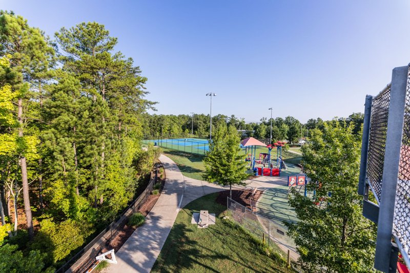 Playground and tennis courts at Church Street Park in Morrisville, North Carolina with walking trails and trees