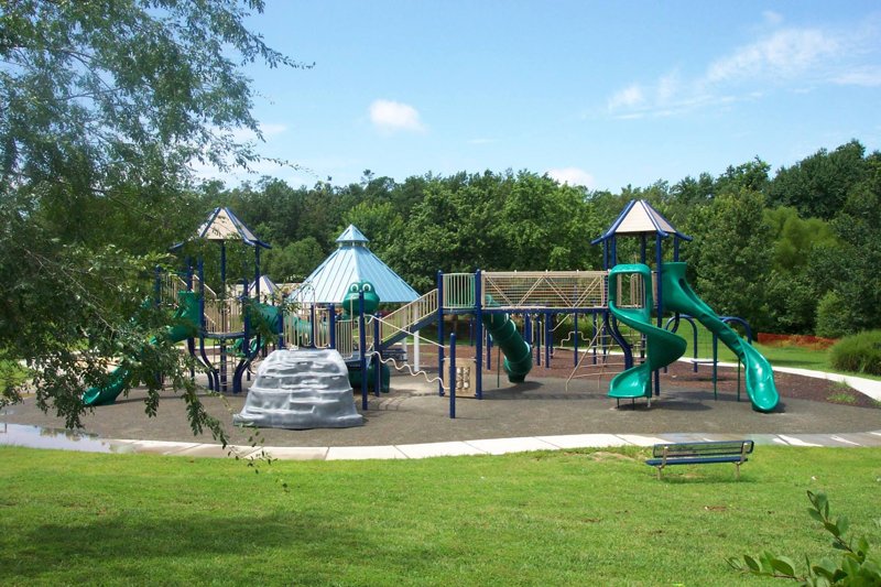Large playground structure at Morrisville Community Park in Morrisville, North Carolina surrounded by green space
