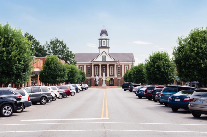 Downtown street view of Pittsboro, North Carolina featuring historic courthouse and parked cars