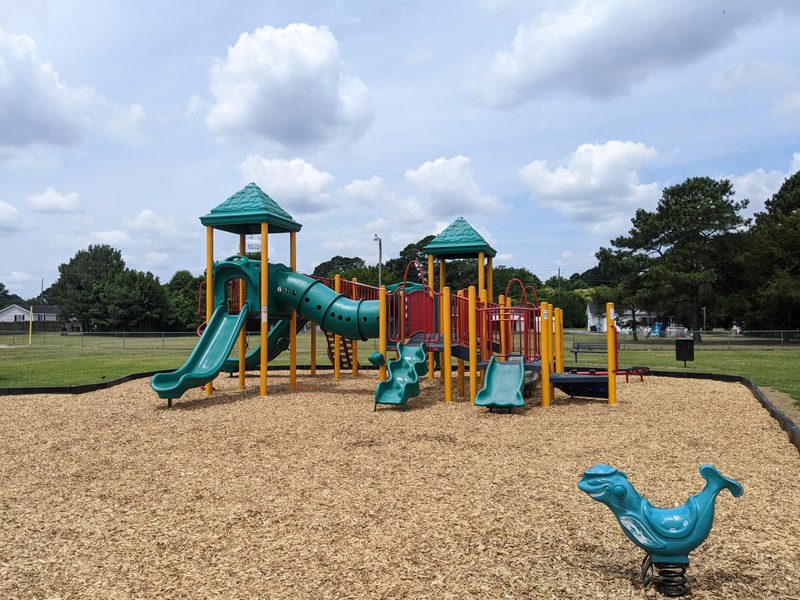 Playground equipment at Sam Goodwin Park with slides and open field in Selma, North Carolina.