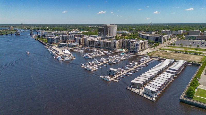 Aerial view of Wilmington Riverwalk marina with boats docked along the waterfront in Wilmington, NC.