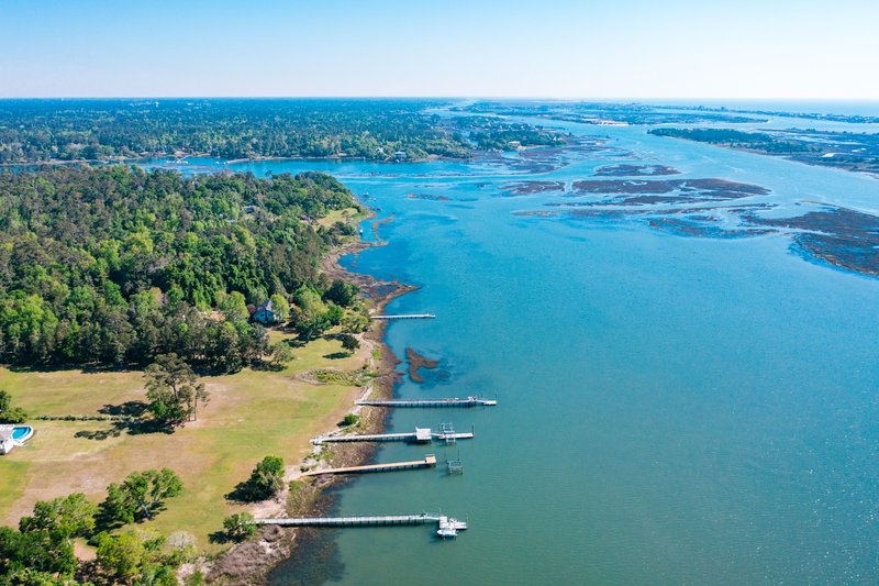 Aerial view of the Intracoastal Waterway with marshlands and docks near Wilmington, NC.