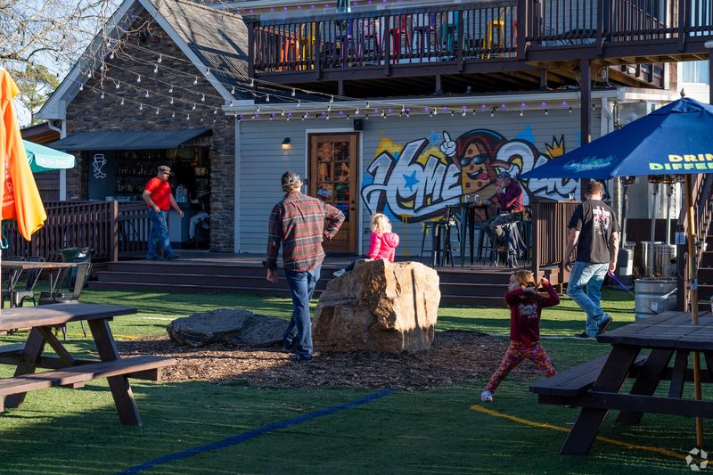Outdoor seating and gathering area at HomeSlice Pizza with people enjoying food in Youngsville, North Carolina.